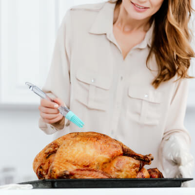 Woman basting turkey