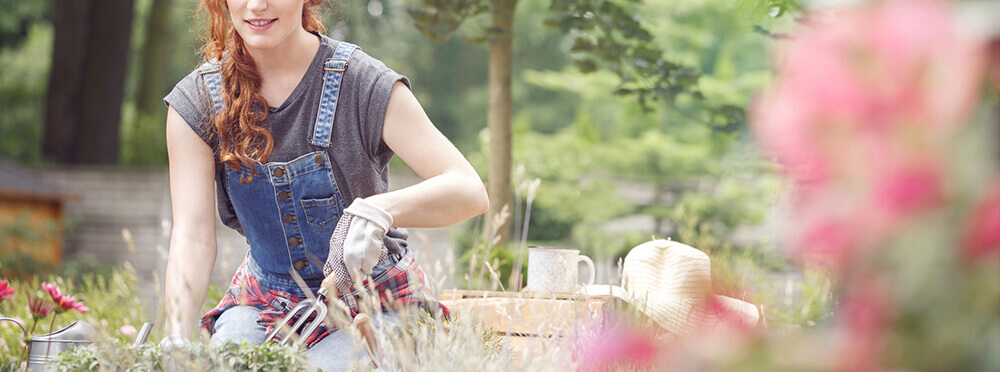 Woman in garden with flower in foreground