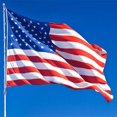 American Flag Waving in Wind Against Cloudless Blue Sky