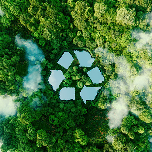 An aerial image of a lush green forest, with wispy clouds and a set of Photoshopped ponds appearing in the shape of the common recycling symbol, a triangle composed of arrows.
