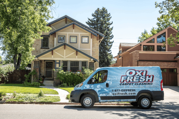 This image shows an Oxi Fresh vehicle parked in front of two suburban homes on a sunny day.