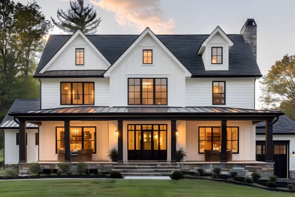 A white house with its indoor lights on viewed from the front lawn.