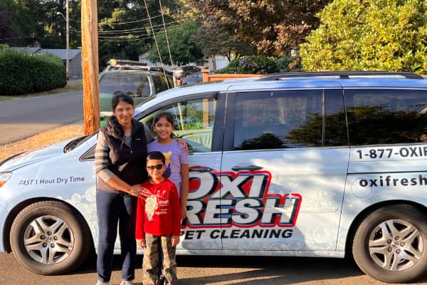 Sonia Garg and her children stand in front of an Oxi Fresh van.
